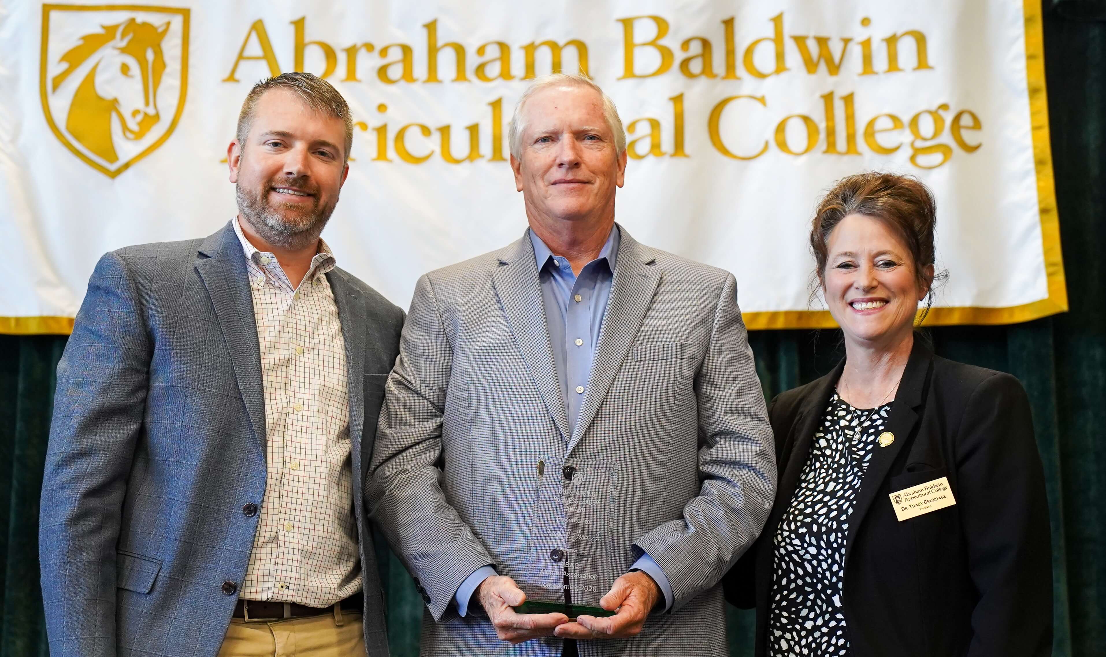 three people at an award presentation